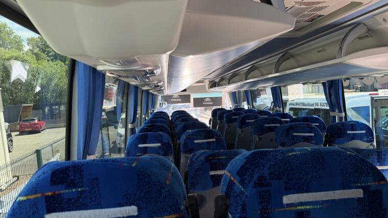 Inside a White Bus Scotland coach, blue seats down the aisle