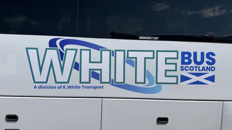 The White Bus Scotland livery on the side of the coach