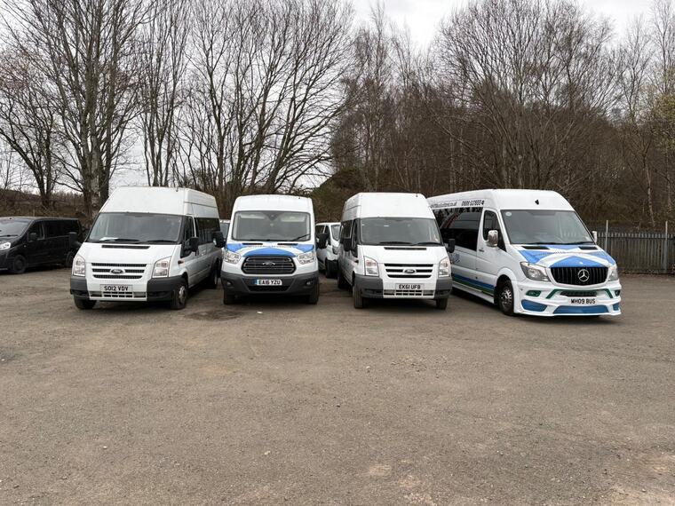 The White Bus Scotland minibuses lined up in the yard