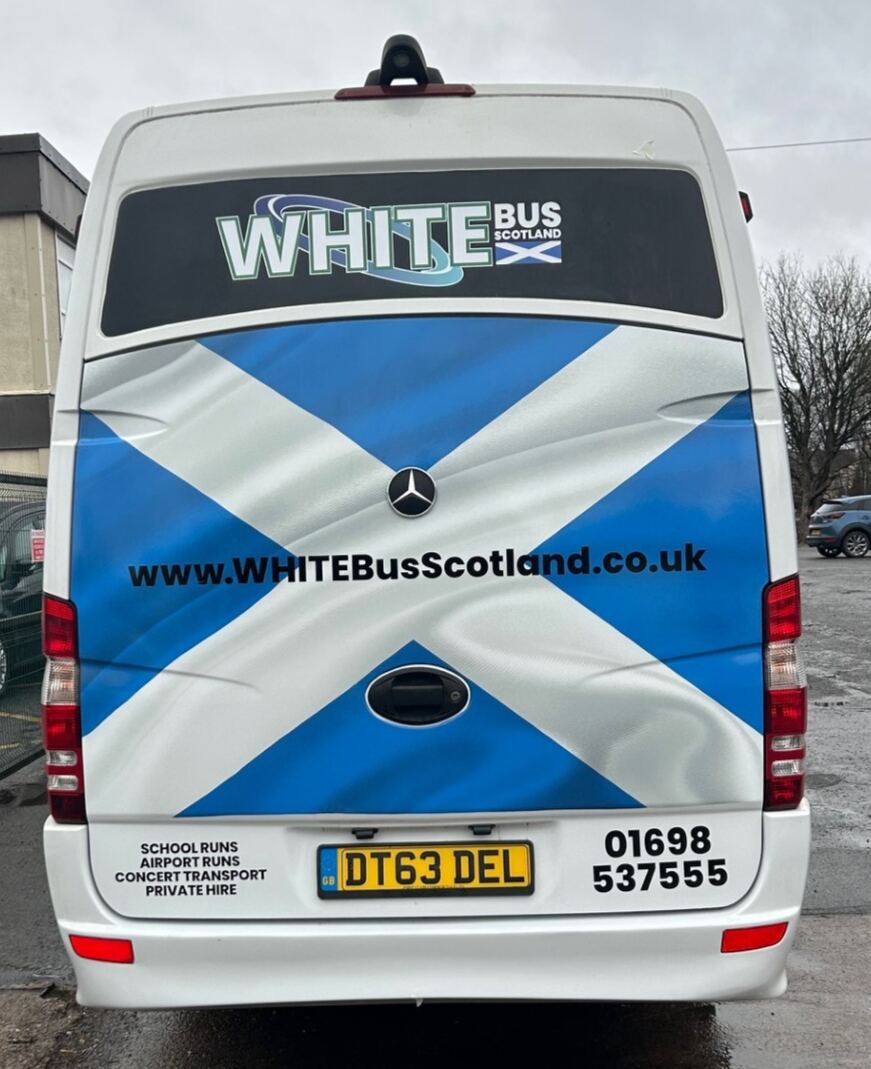 The back of a White Bus Scotland minibus, saltire livery and the phone number 01698 537555
